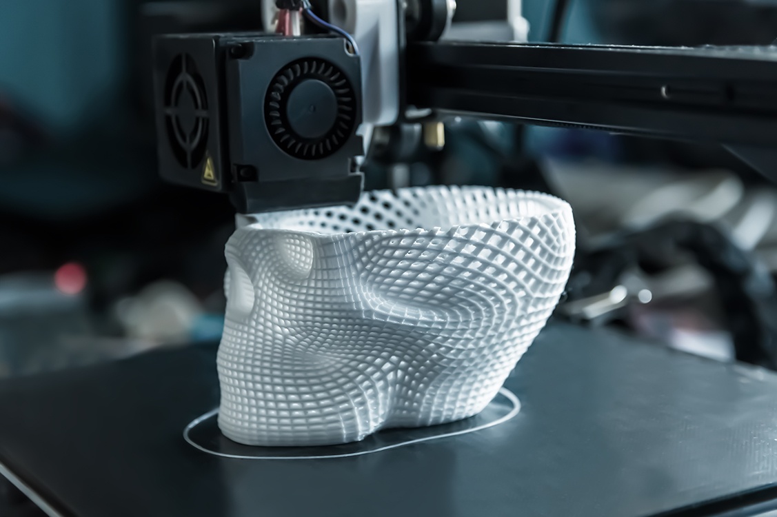 La impresora 3D imprime un modelo de plástico blanco.